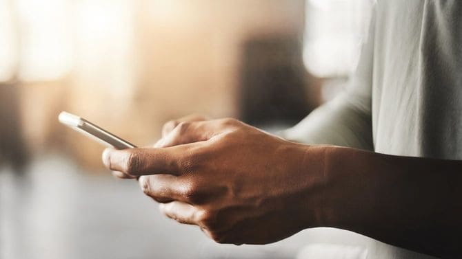 ジムでスマートフォンを使用している男性の手元