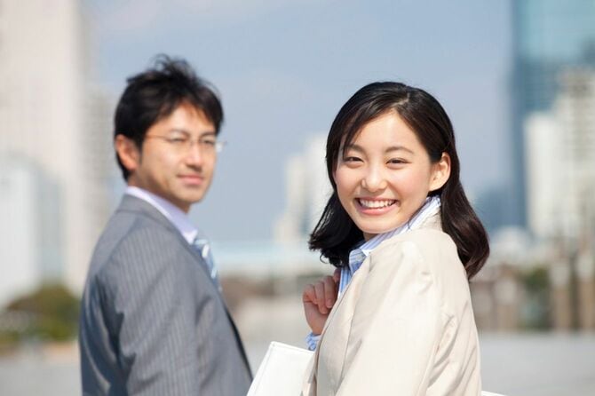 振り返る笑顔のビジネスマンとビジネスウーマン