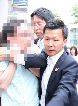 第25回参議院選挙で、安倍晋三首相の演説中に「安倍帰れ」などとヤジを飛ばし、北海道警に移動を促される男性（左）＝15日、札幌市中央区