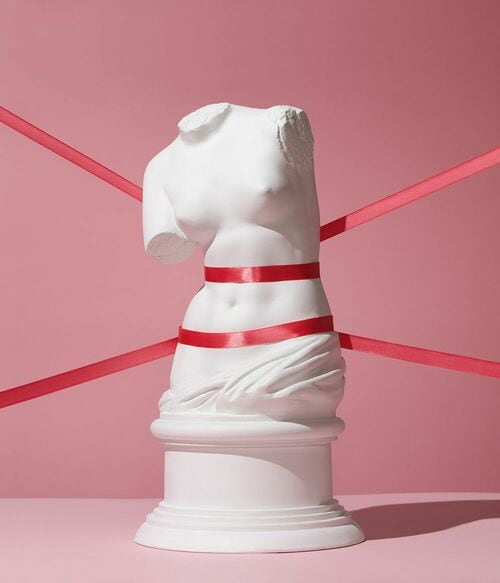 リボンで縛られたミロのビーナスの胴体部分のレプリカ