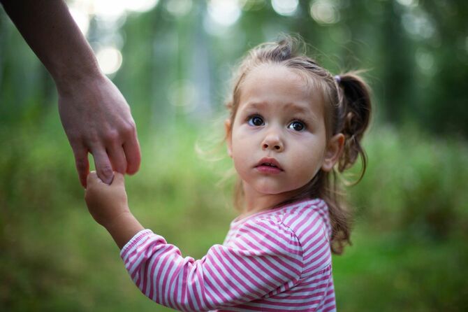 母の手を握る小さなかわいい女の子
