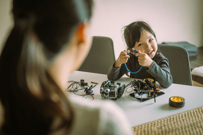 母親と一緒にロボットのおもちゃを作る子供