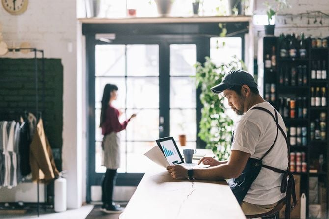 仕事の資料を見る人と店内にいる人のイメージ