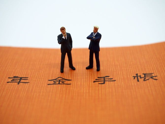 年金手帳と2人のビジネスマン