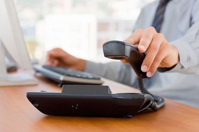 電話の受話器を取るビジネスマン