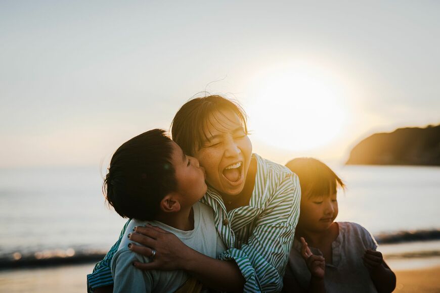 夕暮れ時のビーチでくつろぐ日本人母子
