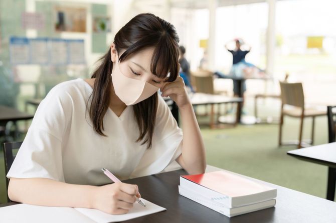 マスクを着用して教室で勉強している女子学生
