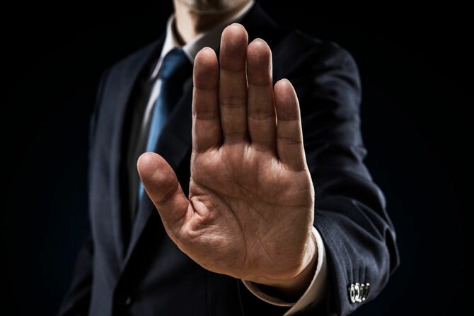 手を突き出して拒否するビジネスマン