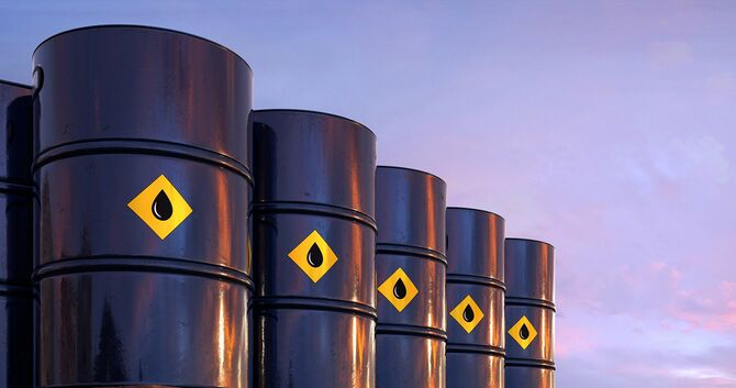 夕焼けの空の下、工業環境にある石油樽の列