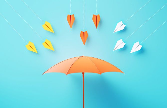 傘に向かって飛んでくるたくさんの紙飛行機