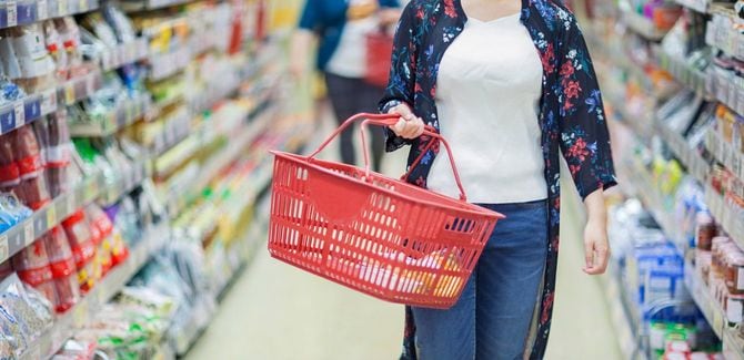 買い物かごを持って買い物中の女性