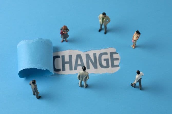 ミニチュア人形が集まり、中央の破けた画用紙には「CHANGE」の文字