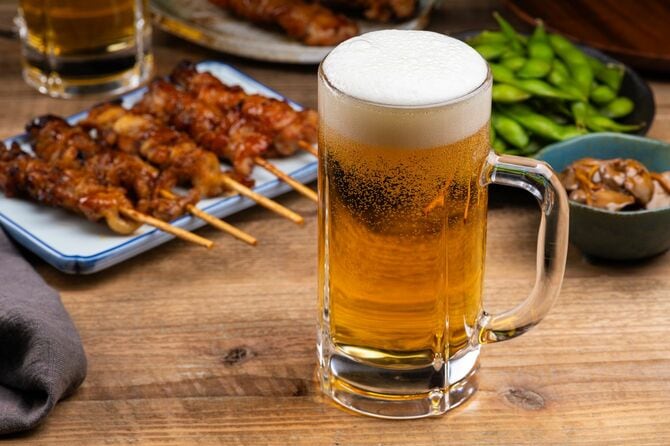 居酒屋のテーブルにビールと焼き鳥やおつまみ
