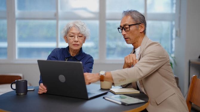 ビジネスマンに財務アドバイスを提供するシニアビジネスウーマン