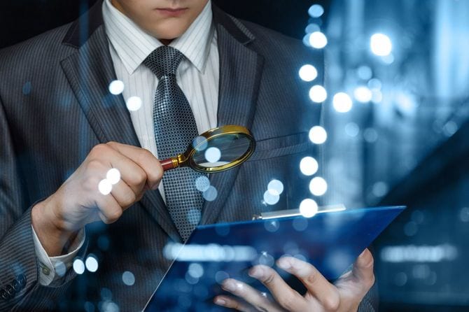 ルーペを使って書類を見る人