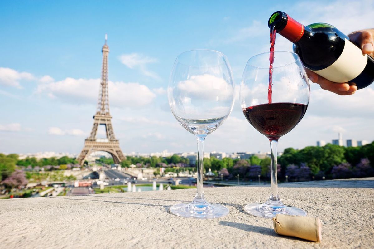 エッフェル塔が見渡せる場所でグラスに赤ワインを注ぐ