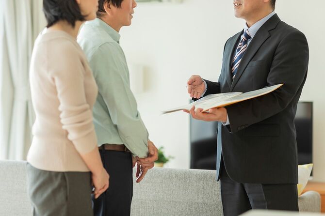 中年夫婦に説明するビジネスマン