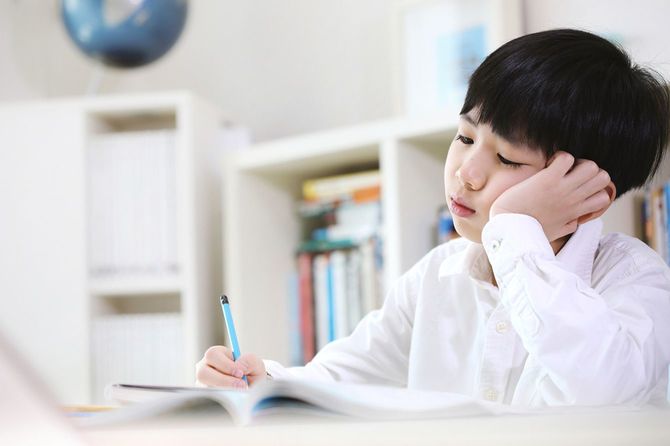 退屈な勉強にうんざりした疲れた生徒と学校の宿題が山積みに