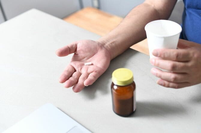 薬を飲む人の手