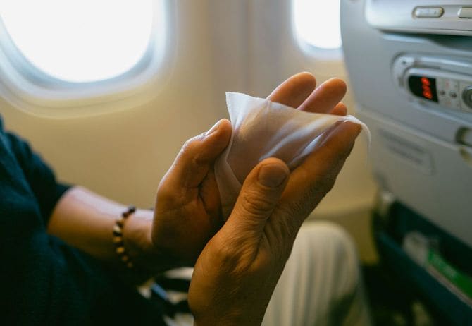 飛行機内でウェットティッシュを使う乗客