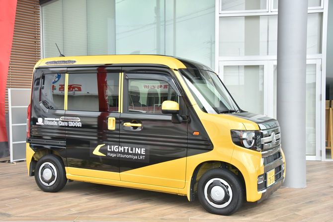 ライトライン沿線の自動車販売店にはライトラインの車体カラーと同じ配色の車があり、沿線住民に親しまれていることを窺わせる（2023年9月撮影）