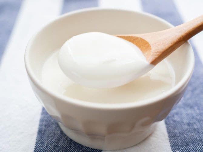 ヨーグルトを木製スプーンですくう