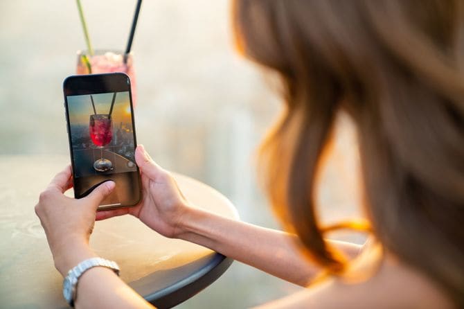 カクテルをスマホで撮影する女性