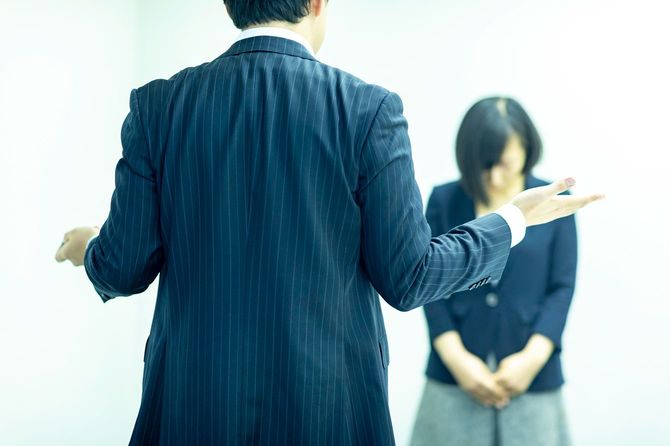 怒るビジネスマンと謝罪する女性