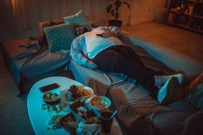 ソファで寝ている太った男