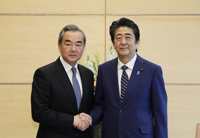 2019年11月25日、首相官邸で中華人民共和国の王毅国務委員兼外相を出迎える安倍首相（当時）