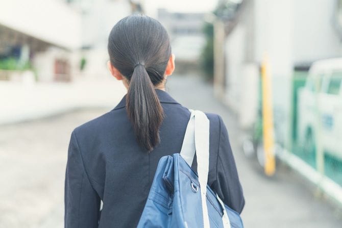 道を歩く女子生徒の後ろ姿