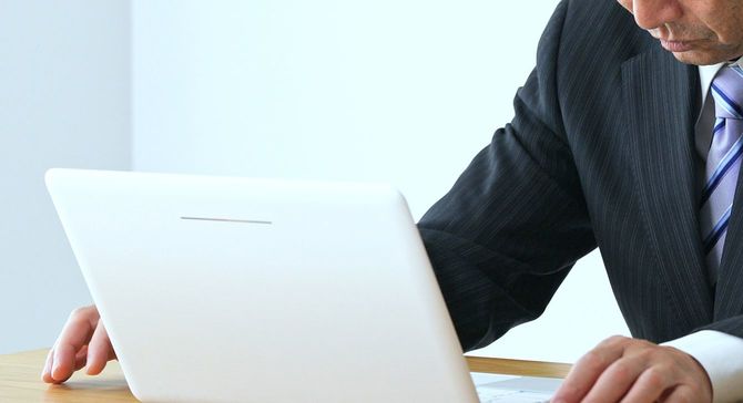 ラップトップコンピュータで中年ビジネスマンを考える。