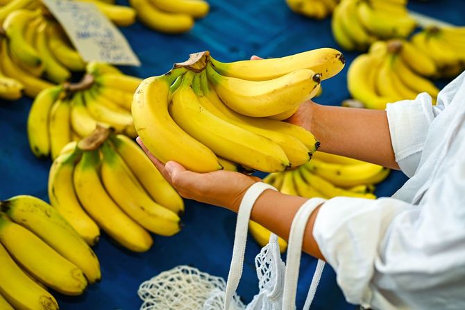 市場でバナナを手に取る女性