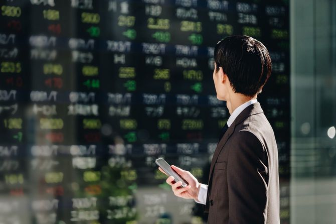 株価ボードを見る男性