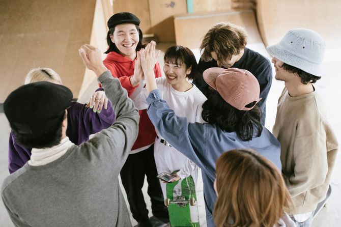 嬉しそうにハイタッチするスケートボーダーのグループ