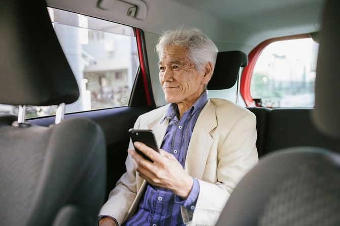 タクシーの後部座席でほほ笑む男性