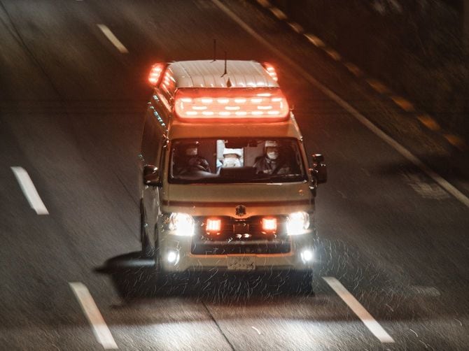雨の中を緊急走行する救急車
