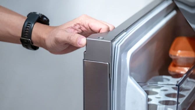 冷蔵庫を開ける男性の手元