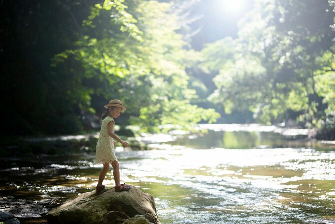 山の中の川で遊ぶ少女