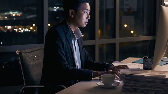 夜遅くまでオフィスで残業をする人