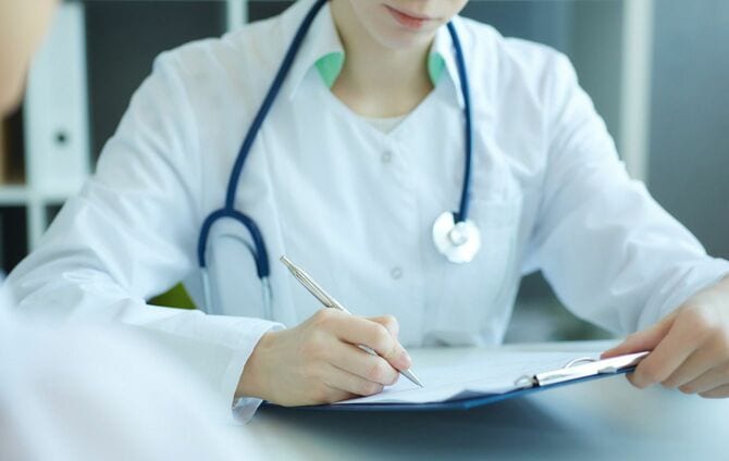 クリップボードに記入する医師