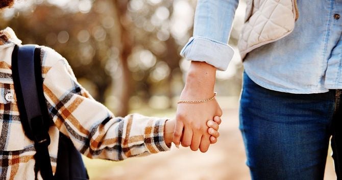 手をつないで歩く母親と子供