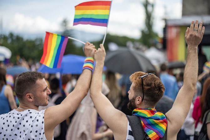 レインボーフラッグを振るカップル