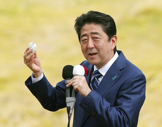 衆院選の応援演説でおにぎりを試食する安倍首相=2017年10月、福島市