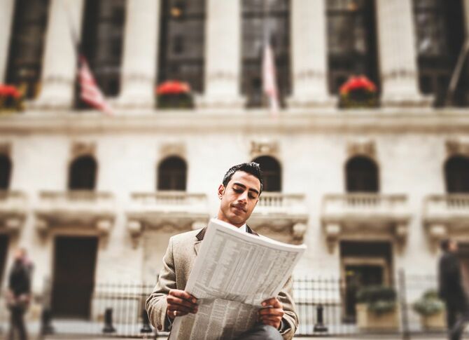ウォール街で新聞を読むビジネスマン