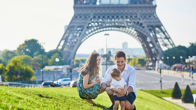 エッフェル塔の近くで、休日を楽しむ幸せそうな親子3人