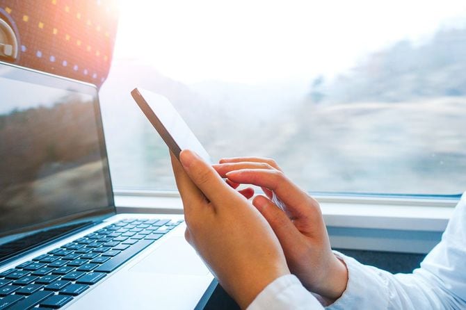 電車内でスマートフォンを操作する男性