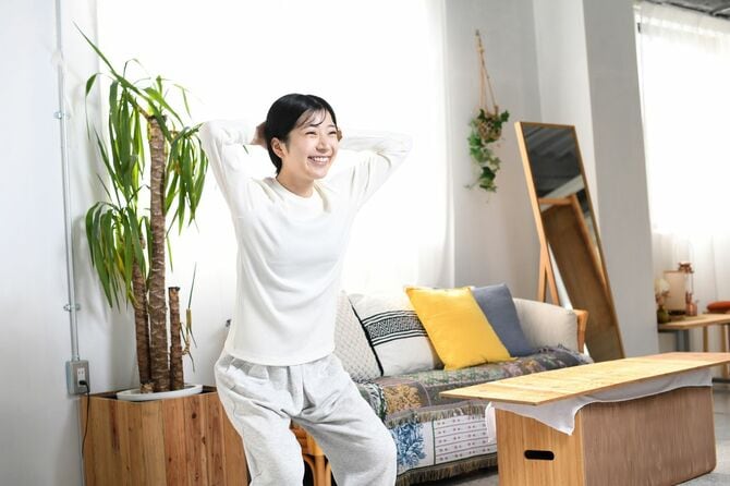 自宅で自重筋トレ(スクワット)をしている若い女性