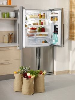 開かれた冷蔵庫のドアといっぱいショッピングバッグ