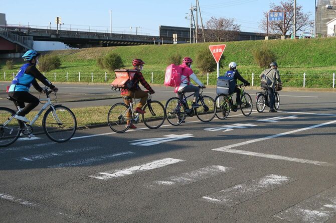 フードデリバリーの従事者に自転車の走行ルールを指導する疋田さん（一番右）